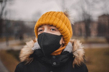 Siyah tıbbi maskeli ve turuncu şapkalı genç. Coronavirus, Çin 'de yaygın bir virüstür. Hastalıktan korunmak için. Sağlık güvenliği kavramı.