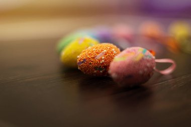 Renkli paskalya yumurtaları koyu ahşap arka planda kapanıyor. Yan görünüm, metin ve yazım için boşluk kopyala. Paskalya bayramı konsepti ve Nisan titreşimleri