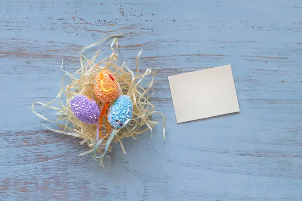 Kolorowe Jaja Wielkanocne Gnieździe Siana Czysta Kartka Układająca Się Niebieskim — Zdjęcie stockowe