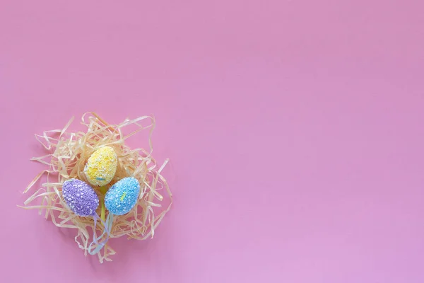 五彩斑斓的复活节彩蛋和一张空白卡片夹在粉红色背景的绳子上 复活节假期的概念 复制空间 文本和措词的位置 四月的活动 — 图库照片