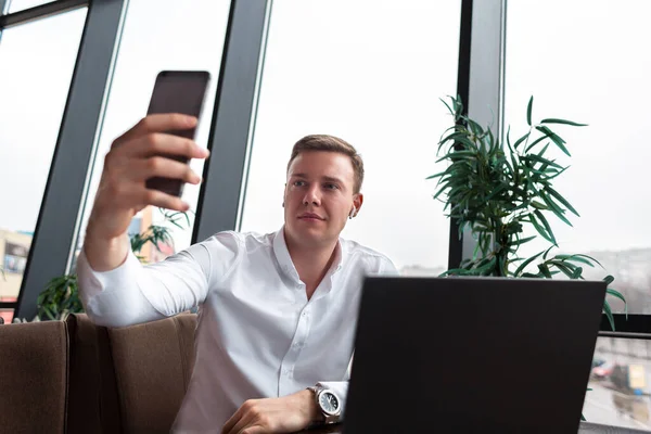 Młody Biznesmen Białej Koszuli Robiący Selfie Komórce Kawiarni Laptopem Koncepcja — Zdjęcie stockowe