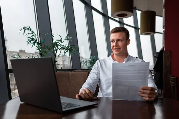 Młody Biznesmen Białej Koszuli Siedzi Kawiarni Laptopem Dokumentami Uśmiechnięty Cieszący — Zdjęcie stockowe