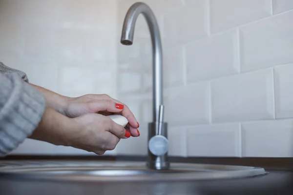Молодая женщина моет руки с мылом, чтобы предотвратить коронавирусную инфекцию. Руки с красными ногтями тщательно промываются для поддержания гигиены. Безопасность вирусов. Ковид-19 . — стоковое фото