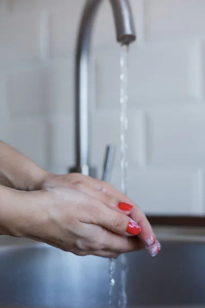 Primer plano de la mujer joven se lava las manos con jabón para prevenir la infección por coronavirus. Las manos con uñas rojas se lavan espinosamente para mantener la higiene. Seguridad del virus. Concepto de parada Covid-19 . — Foto de Stock