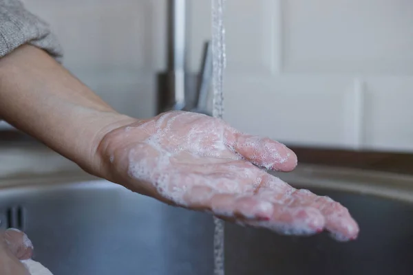 Close-up van jonge vrouw wast haar handen met zeep om coronavirusinfectie te voorkomen. Handen met rode nagels worden grondig gewassen om de hygiëne te handhaven. Virusveiligheid. Covid-19 stopconcept. — Stockfoto