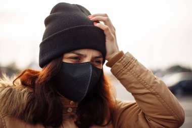 Siyah maskeli hasta, maske takan, sıcağa yakalanmış, başı ağrıyan, kötü hisseden hasta bir kız. Birinin yardıma ihtiyacı var..