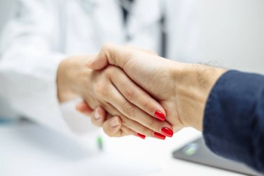 Kadın bir doktor ve hastanın ellerinin yakınlaştırılması. Bir çözüm ve anlaşma bulduktan sonra bir hastayla tedavi ve tokalaşma hakkında konuşmak. Coronavirus test ve önleme konsepti