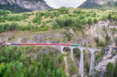 İsviçre 'deki Alp Dağları' nın kalbi Filisur 'daki ünlü Landwasser köprüsünden geçen kırmızı ekspres tren.