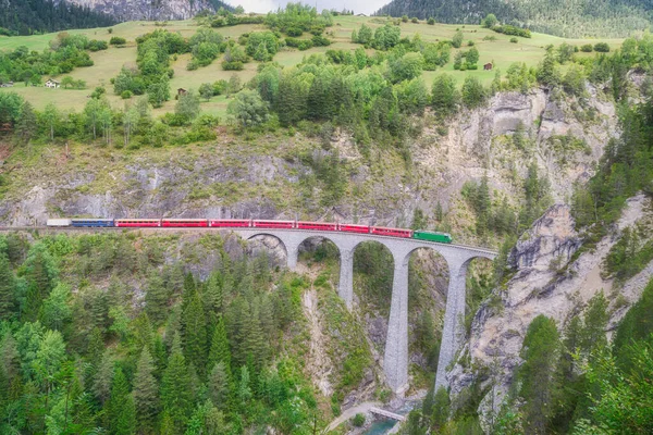 红色特快列车在瑞士阿尔卑斯山中心地带菲利苏尔著名的Landwasser桥上行驶 — 图库照片