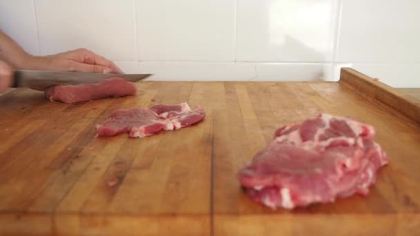 木製の板の上にナイフで肉を切断赤い再生エプロンと女の子の手 — ストック動画