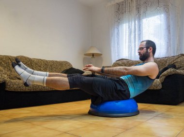 Evde bosu topu şınavı yapan kaslı bir adam. Spor anlayışı.