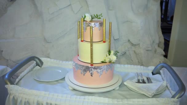 Гарний триярусний торт стоїть на візку офіціанта поруч з столовими приборами — стокове відео