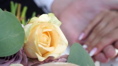 Damat buket arka planda gelinin elini hafifçe okşuyor.