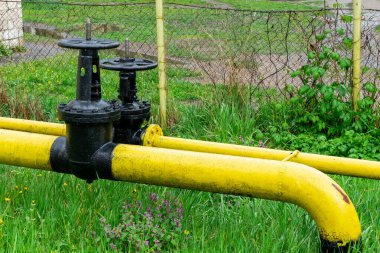 Sarı gaz borusunda iki büyük siyah valf.