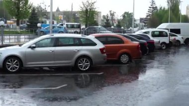 Sokakta yağmur yağıyor. Araba otoparktan ayrılıyor.