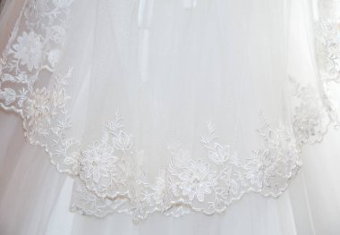 Gelinin beyaz elbisesinin bir kısmı nakışla süslenmiş.