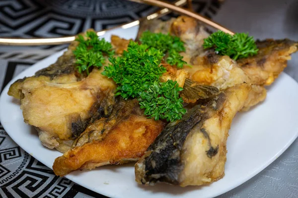パセリで飾られた黄金の揚げ魚 魚を鉄板で揚げたもの — ストック写真