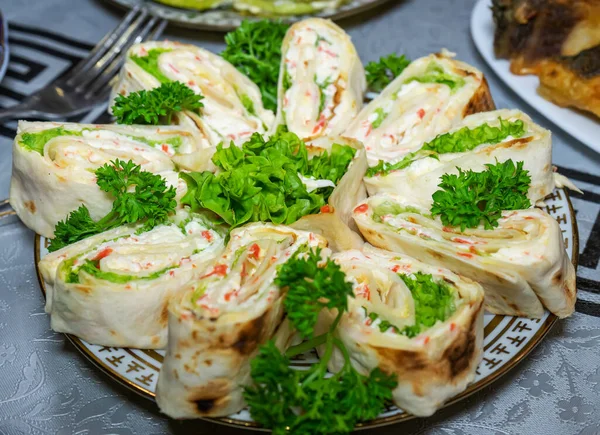 Maydanozla süslenmiş tabakta peynirli pide ve deniz mahsulü.