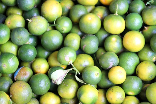 Зеленые и желтые фрукты лайма на рынке — стоковое фото