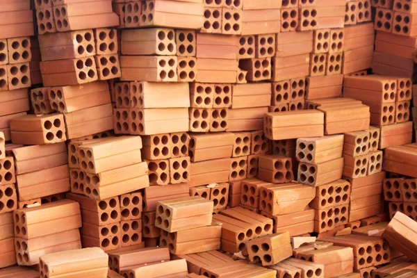 A Stack of orange 4 hole bricks in construction site — Stock Photo, Image