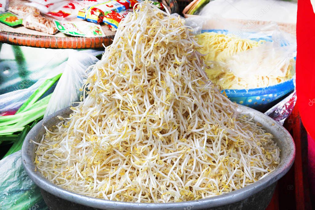 Fresh soybean sprouts lie in a basin in a market