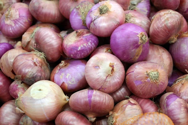 Фиолетовый лук продают на рынке — стоковое фото