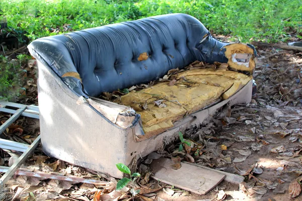 Vecchio divano rotto gettato nella spazzatura Immagine Stock