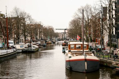 Amsterdam, Hollanda, 01 / 18 / 2008; Amsterdad Kanalı, nehrin her iki yakasında tekne ve evler ve etrafındaki evler
