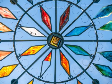 Mavi, kırmızı, turuncu, beyaz, arka planda mavi gökyüzü olan lekeli cam pencereler.