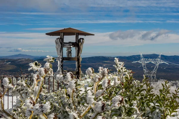 雪の日に高電圧タワーの後ろに山の凍結茂みの間の街灯 — ストック写真