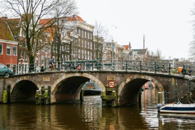 Amsterdam, Hollanda, 01 / 18 / 2008; Arka planda binalar bulunan Amsterdam kanalı üzerindeki köprü