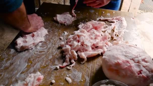 两个工人在厨房里用盐揉碎猪肉的软脂当调味品 — 图库视频影像
