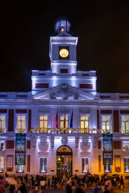 Madrid, İspanya; 12 / 17 / 2019: Plaza Sol 'daki kraliyet postanesinin önünde kalabalık ve Noel ışıklandırmasıyla cephesi