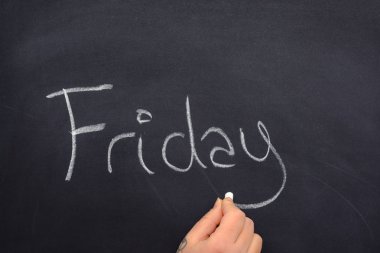 Haftanın bir günü beyaz tebeşirle yazı yazan bir kadın.