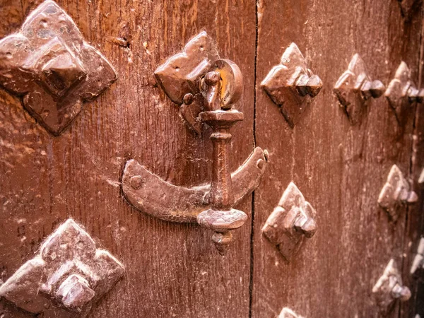 Metalowy Kołatacz Starych Drewnianych Drzwiach Otoczony Odstraszającymi Szaszłykami — Zdjęcie stockowe