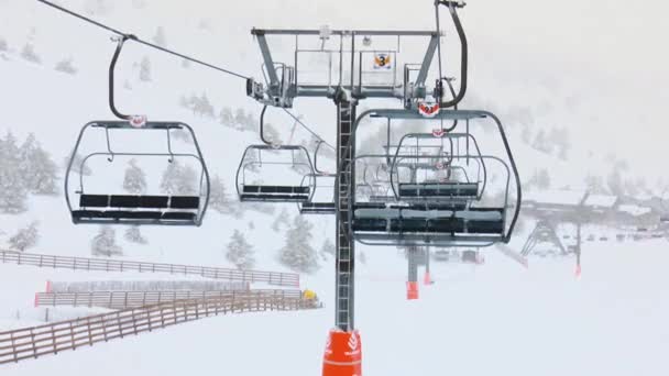霧深い日の雪の中 リゾートに降りるスキーリゾートのチェアリフト — ストック動画