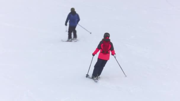 Dos Esquiadores Descienden Esquiando Una Pista Nevada Una Estación Esquí — Vídeo de stock