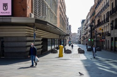 Madrid, Spain; 03/15/2020: Preciados street  in Madrid with fewer people than usual and a man wearing a mask due to the state of alarm and the confinement decreed because of the Coronavirus, Covid19 clipart