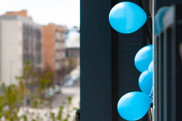 青い風船はスペインのコロナウイルス警報中の建物のバルコニーを背景に通りで飾る — ストック写真