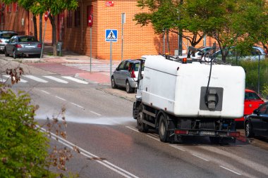 San Sebastin de los Reyes, Madrid, İspanya; 04 / 11 / 2020: Coronavirus 'a karşı duyarlılık nedeniyle sokakları dezenfekte sıvısıyla dezenfekte eden kamyon