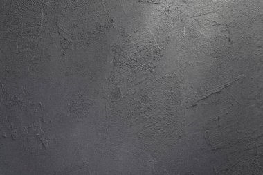 Gri taştan bir duvarın arkaplandaki görüntüsü içinden bir ışık huzmesi geçiyor.