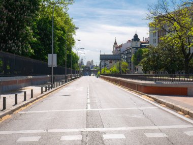 Madrid, İspanya, 05 / 01 / 2020: O 'Donnell Caddesi, Retiro Park' ın yanındaki, arkasında büyük siyah bir kurdele bulunan Puerta de Alcala ile koronavirüs nedeniyle alarm durumu nedeniyle tamamen boş