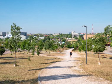 San Sebastian de los Reyes, Madrid, İspanya, 05 / 23 / 2020: Koronavirüs alarm devleti sırasında bir parkın yolunda yürüyen ve spor yapan insanlar. İnfanta Sofya hastanesinin yakınında.