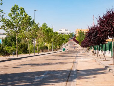 San Sebastian de los Reyes, Madrid, İspanya, 05 / 23 / 2020: Koronavirüs alarm durumu sırasında yayaların özel kullanımı için kapalı bir yolda yürüyen ve spor yapan insanlar
