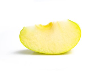 Beyaz arka planda yeşil elma kesiği. Kapat.