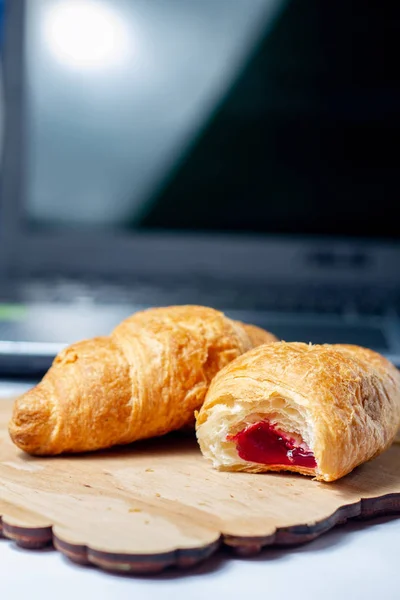 Croissanter Biten Med Jordgubbssylt Med Torrt Vete Träskiva Bärbar Dator — Stockfoto