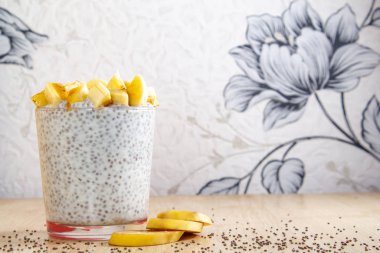 Sağlıklı kahvaltıda chia yoğurdu ve muz tohumları ahşap arka plan fitness yiyeceğinde. Boşluğu kopyala