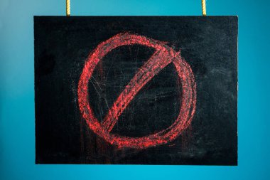 Tebeşir tahtası, mavi arka planda kırmızı yasaklama işareti ile askıya alınmıştır. Boşluğu kopyala