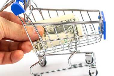 Mavili sepet beyaz arka plana bir dolarlık banknot yerleştirir. izole et