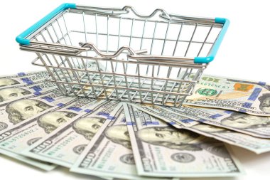 İçine mavi eklenmiş sepet beyaz arka planda yüz dolarlık banknotların üzerinde duruyor. izole et